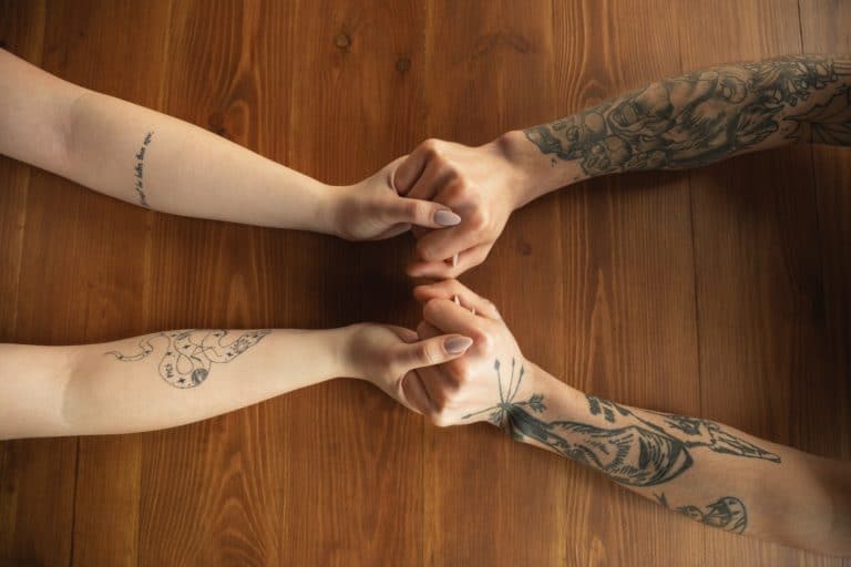 Loving couple holding hands close-up on wooden background, romantic